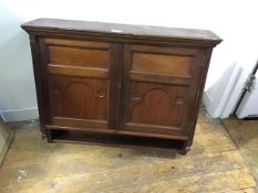 An Edwardian walnut wall cabinet, the moulded top above a pair of inset fielded panel doors,