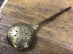 A late 19thc bedwarming pan with turned fruitwood handle, with pierced engraved hinged front, with