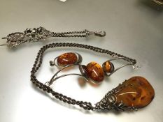 A white metal modern amber mounted bracelet, a large amber white metal mounted pendant on rope