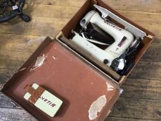 A Helvetia portable electric vintage sewing machine in composition case, complete with parts etc.