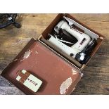 A Helvetia portable electric vintage sewing machine in composition case, complete with parts etc.