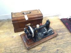 A late 19thc/early 20thc hand sewing machine with walnut inlaid case, with handle to top (catch does