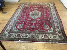 A Tabriz rug, the centre medallion enclosed within spiralling lotus flower and leaf border, and