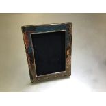 A modern silver rectangular photograph frame (16cm x 13cm outer), on hardwood easel stand (missing