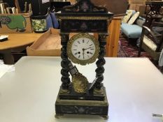 A 19thc ebonised and gilt mounted portico clock with arched top and enamelled dial, with twin key