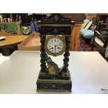 A 19thc ebonised and gilt mounted portico clock with arched top and enamelled dial, with twin key