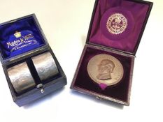 A pair of Mappin & Webb engraved napkin rings and a bronze Richard Cobden, 1804-1865 presentation