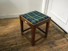 A 1920s oak stool with square top, with inset tartan seat, raised on square tapered supports