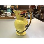 A Burleigh ware pottery ribbed 1930s style jug with four claw dragon handle, yellow ground (h.25cm x