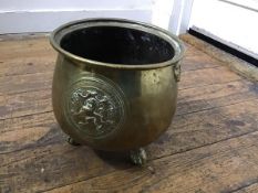 A brass jardiniere with embossed lion mask handles to side, on claw and ball feet (h.23cm x 22cm)