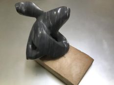 A carved grey and white soapstone abstract sculpture, possibly of an Orca, on base (h.25cm x 26cm