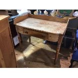 A 19thc stripped pine ledgeback washstand fitted centre drawer, raised on ring turned tapered