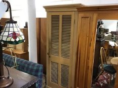 A 19thc stripped pine louvre panel door cupboard with adjustable shelved interior, on plinth base (