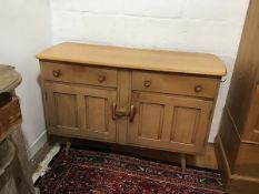 An Ercol light ash sideboard, the shaped top with moulded edge above two frieze drawers and two