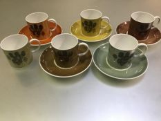 A Susie Cooper china eleven piece coffee set with stylised tree decoration in harlequin colours (