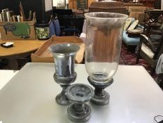 A pair of soapstone circular turned pedestals, one with glass storm lantern bell (h.14cm x 16cm.