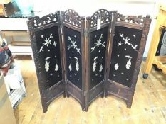 A 1920s Japanese hardwood four fold dwarf screen with carved top rails and lacquered panels, with