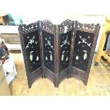 A 1920s Japanese hardwood four fold dwarf screen with carved top rails and lacquered panels, with