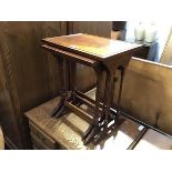 A reproduction mahogany nest of three coffee tables, with moulded edges, on twin faux bamboo