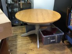 A Marks & Spencer solid oak top Moss-putty extending circular dining table, raised on turned