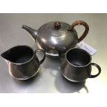 A Liberty Tudric pewter hammered three piece teaset comprising a two handled sugar basin, cream ewer