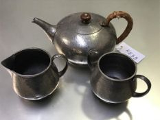 A Liberty Tudric pewter hammered three piece teaset comprising a two handled sugar basin, cream ewer