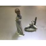 A Nao Spanish porcelain figure, Girl with Puppy (h.20cm) and a group of three Ducks (h.11cm) (2)