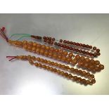 A strand of amberoid style beads on cord, and another two shorter strands (longest: 36cm shortest: