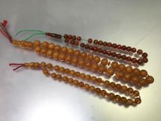 A strand of amberoid style beads on cord, and another two shorter strands (longest: 36cm shortest: