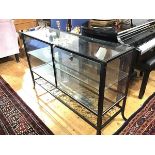 An anodised metal counter style display cabinet, with twin panel doors, and interior glass shelf and