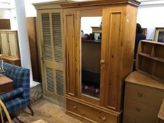 A modern pitch pine wardrobe, the moulded cornice above a centre mirror panel door and single