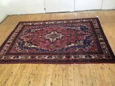 A Tabriz style carpet, the centre medallion enclosed within a scalloped radiating medallion with