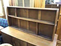 An Ercol oak and elm wall shelf with an arrangement of four sections on shaped side supports (h.50cm