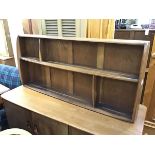 An Ercol oak and elm wall shelf with an arrangement of four sections on shaped side supports (h.50cm