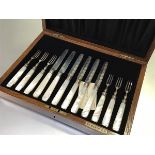 An oak canteen containing a set of six pairs of Birmingham silver engraved bladed fruit knives and