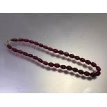 A red graduated amber bead necklace with yellow metal clip fastening (19cm) (19.87g)
