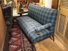 An Edwardian oak framed two seater hall sofa with upholstered panel back, arms and stuffover seat in