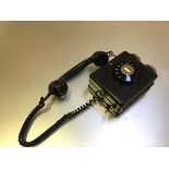 A Weidmann 4259 plastic wall mounted telephone with finger dial and hanging handset (h.21cm x 14cm x