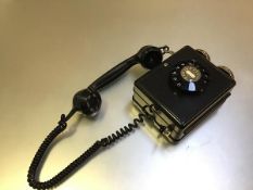 A Weidmann 4259 plastic wall mounted telephone with finger dial and hanging handset (h.21cm x 14cm x