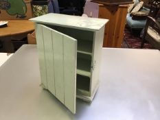 An Edwardian tongue and groove style miniature green painted cabinet with shelved interior, raised