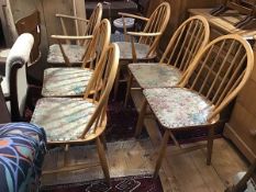 A set of six Ercol style ash spindle back arched dining chairs with later upholstered seats,
