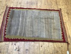 A bagface style kelim rug, with plain centre panel with stylised yellow and red border, complete