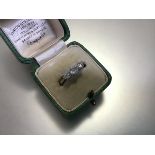 An early 20th century three stone diamond ring, the graduated round brilliant-cut stones claw set on