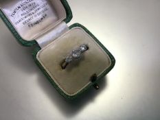 An early 20th century three stone diamond ring, the graduated round brilliant-cut stones claw set on