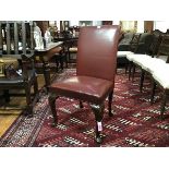 A George III style walnut framed library chair with upholstered ox-blood leather panel back and