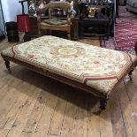 A large ottoman or centre stool, the rectangular seat upholstered in an Aubusson style floral