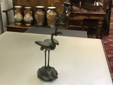 A large Japanese bronze crane candlestick, the bird holding a water lily sprig with candle holder