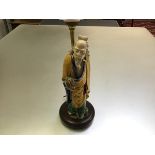 A Chinese pottery figure of a sage, modelled standing holding a peach, in a glaze of Sancai type,
