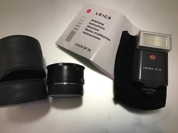 A Leica SF20 Flash (for R&M mount), with instruction booklet; together with a lens adapter marked