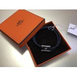 Hermes, a Tournis Tresse plaited leather bracelet, with palladium plated hardware, in original box.